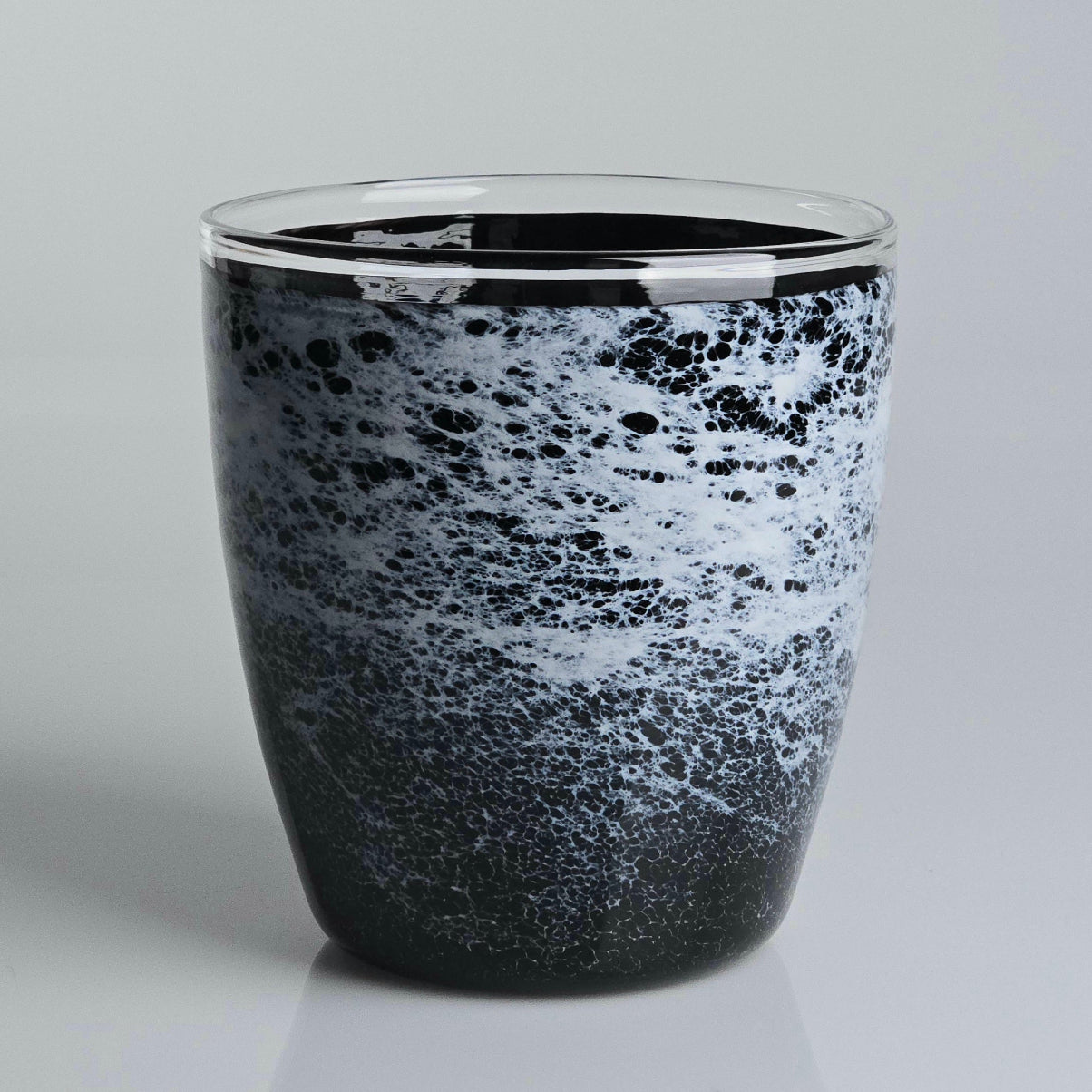 A glass planter with a black and white marbled or speckled pattern, featuring a clear glass rim, set against a light gray background.