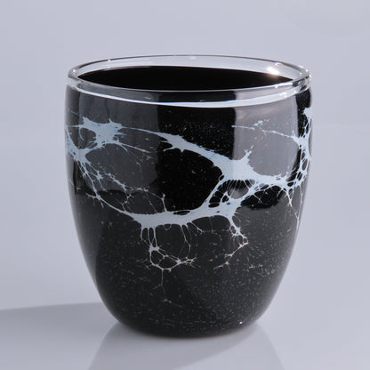 A glossy black glass planter with a white marble vein pattern, photographed on a light gray background.
