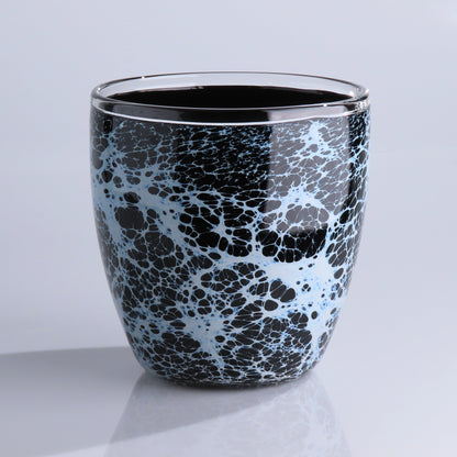 A glossy black glass planter with a white and light blue marble or crackle pattern, set against a clean light gray background.