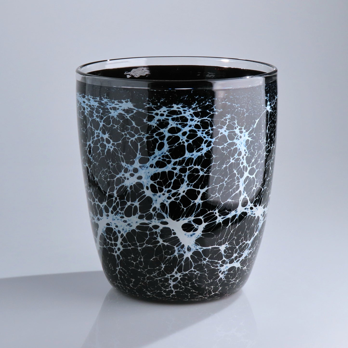 A glossy black glass planter with a white and light blue crackle marble pattern, set against a neutral gray background.