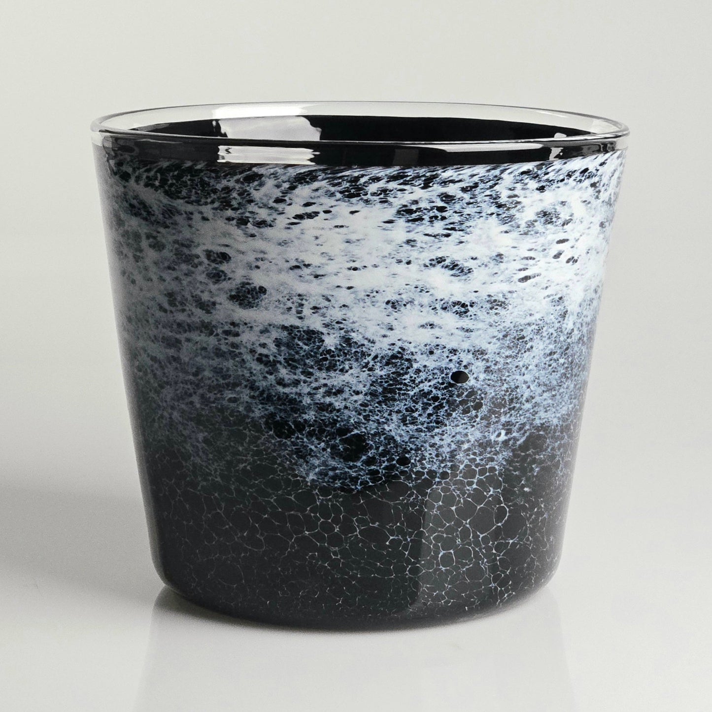 A glass planter with a black and white marbled, speckled pattern, featuring a polished clear rim, set against a light gray background.